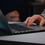 mão mexendo no notebook indicando um site para personal trainer